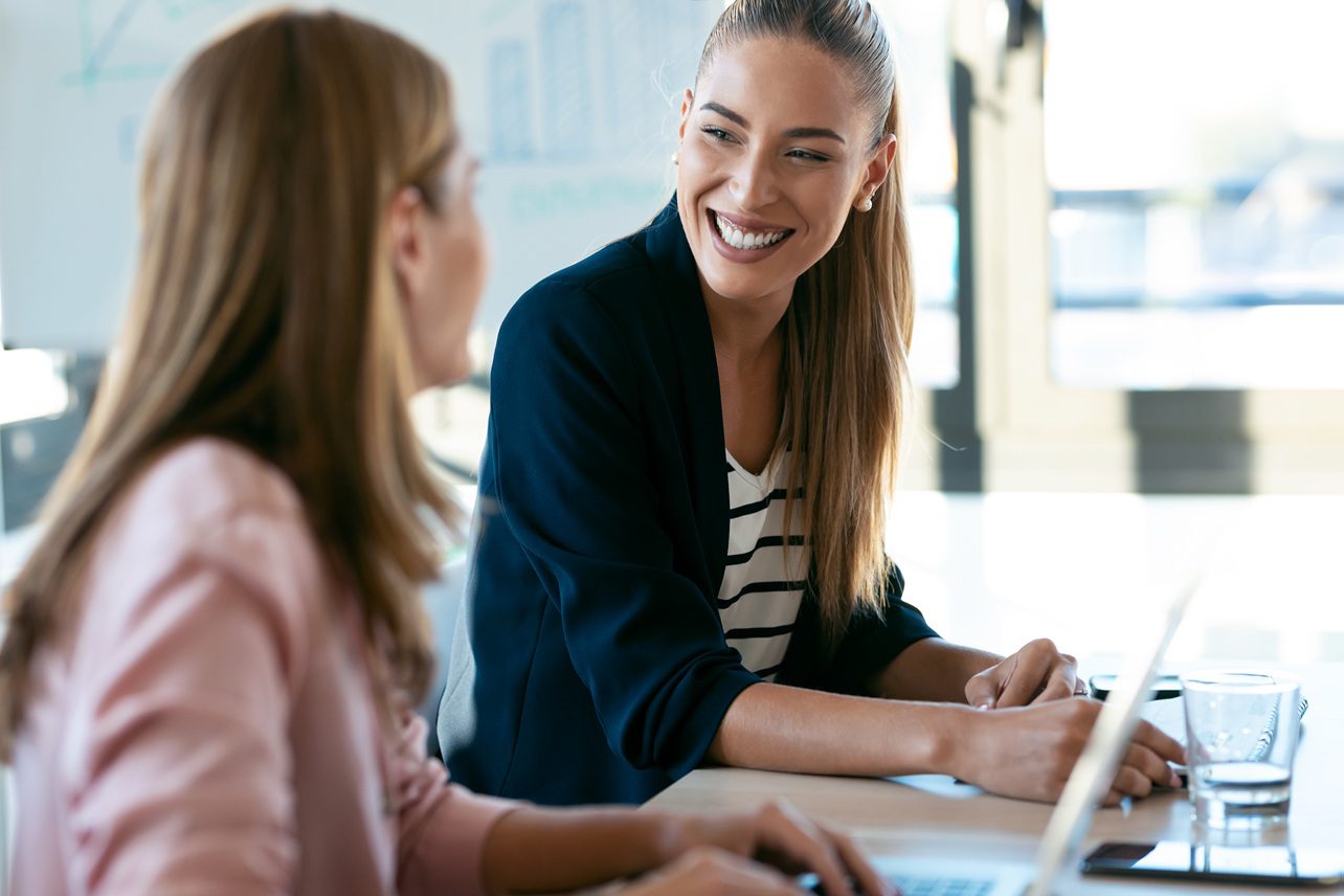 Two business professionals collaborating on a laptop during an accounting consultation